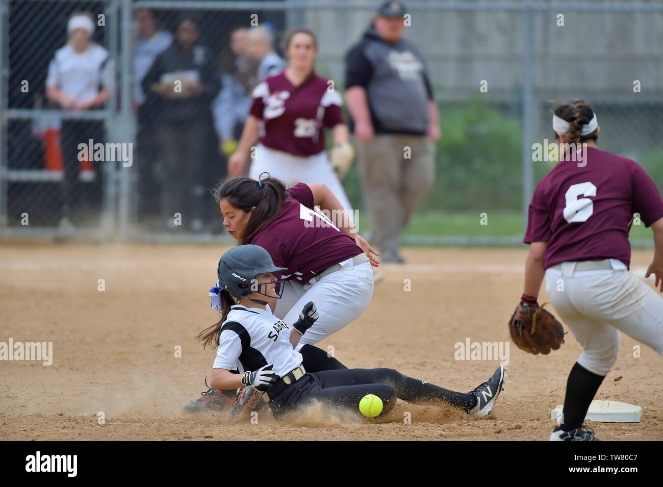 Runner sliding in safely with a steal of second as an opposing infielder has the ball come loose will attempting to apply a tag. USA. Stock Photo