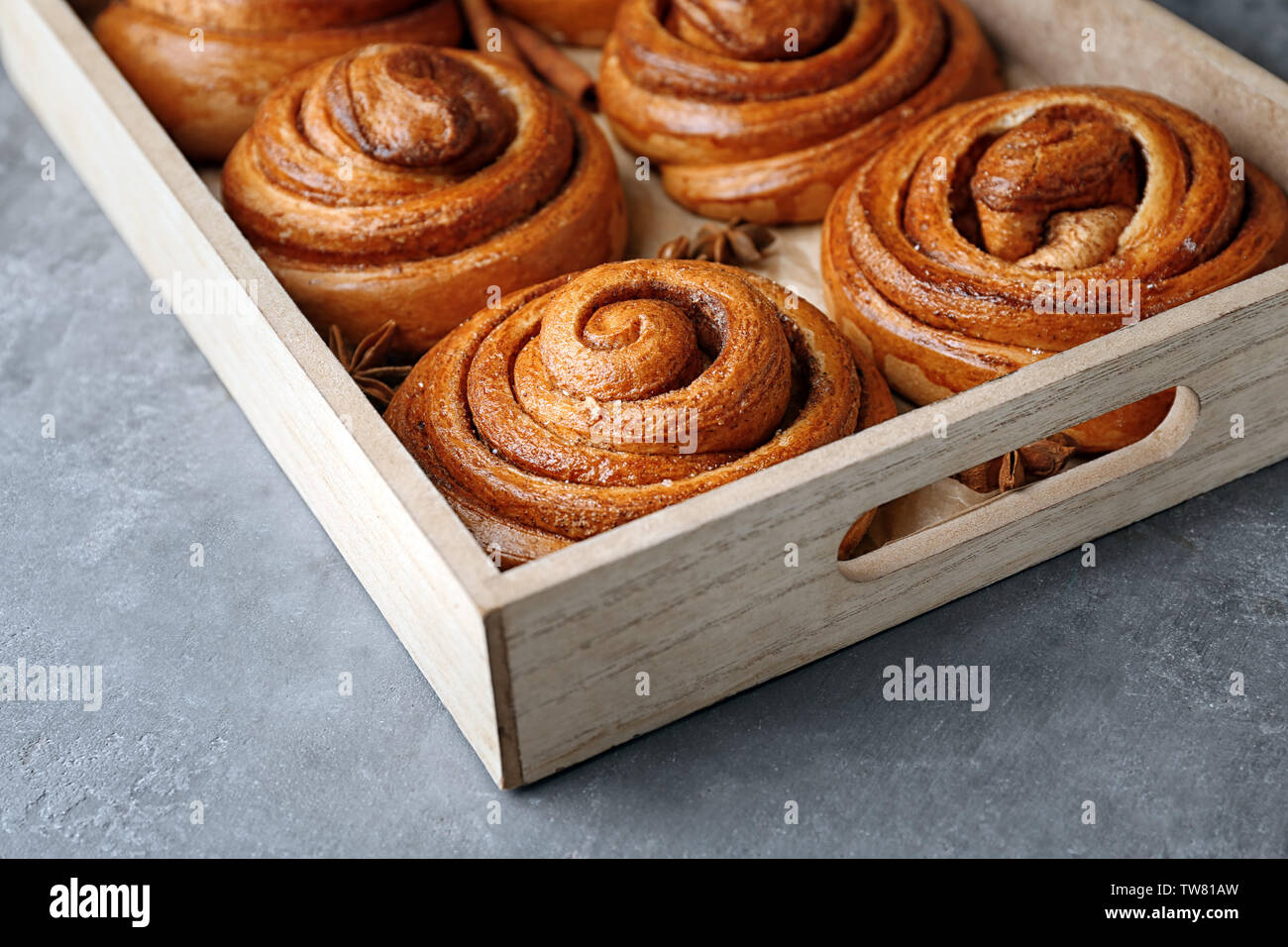 Wooden tray with sweet cinnamon rolls on table Stock Photo - Alamy