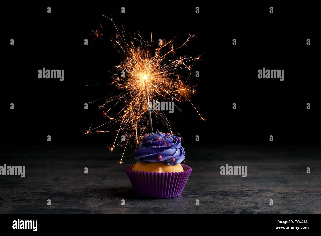 Tasty cupcake on table against black background Stock Photo