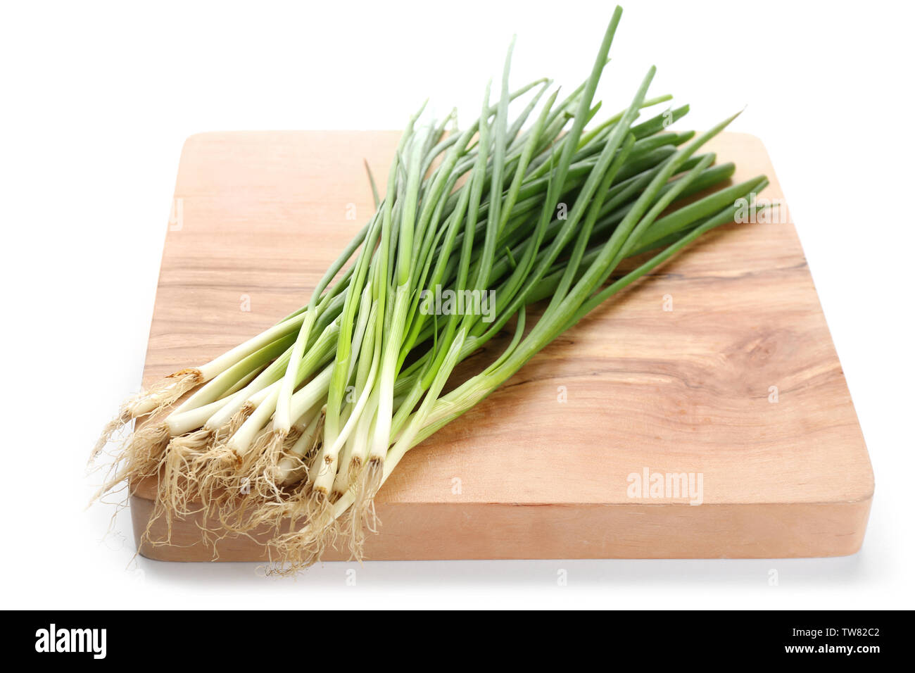 Wooden board with green onion on white background Stock Photo - Alamy