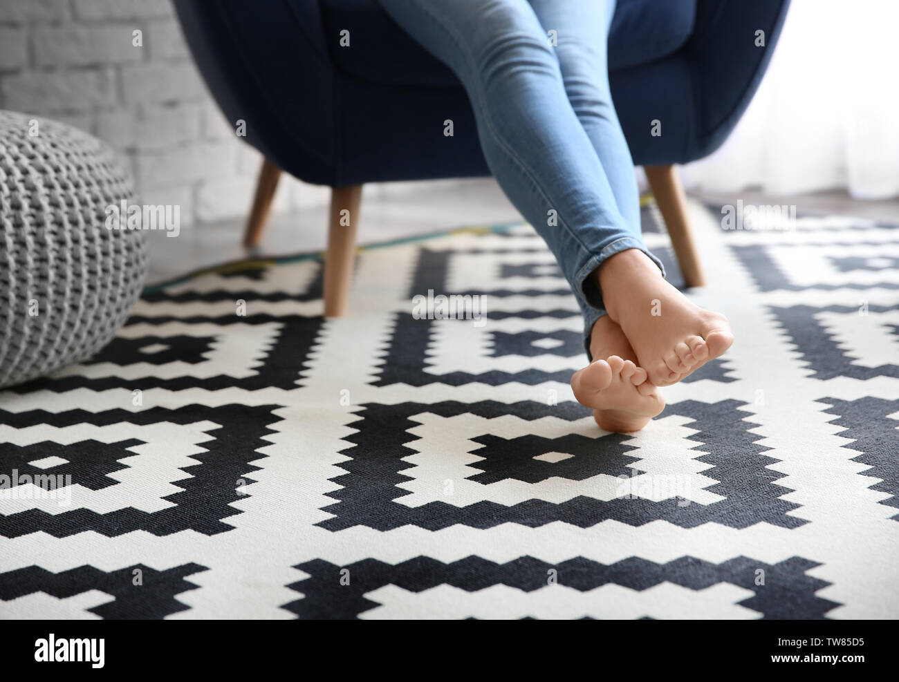 Woman sitting in armchair with feet on carpet at home Stock Photo Alamy
