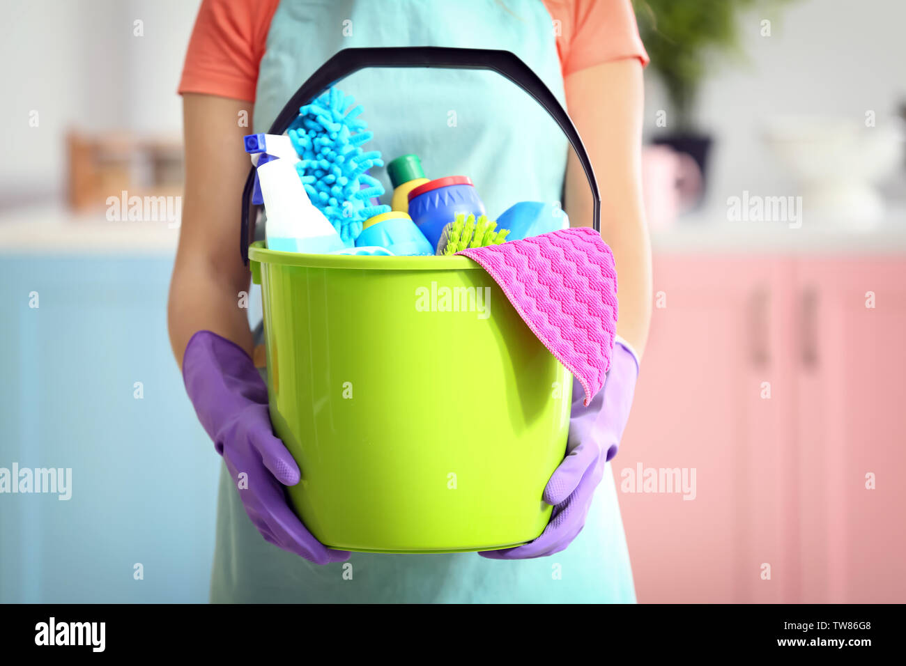 Woman holding bucket with cleaning products and tools indoors Stock ...