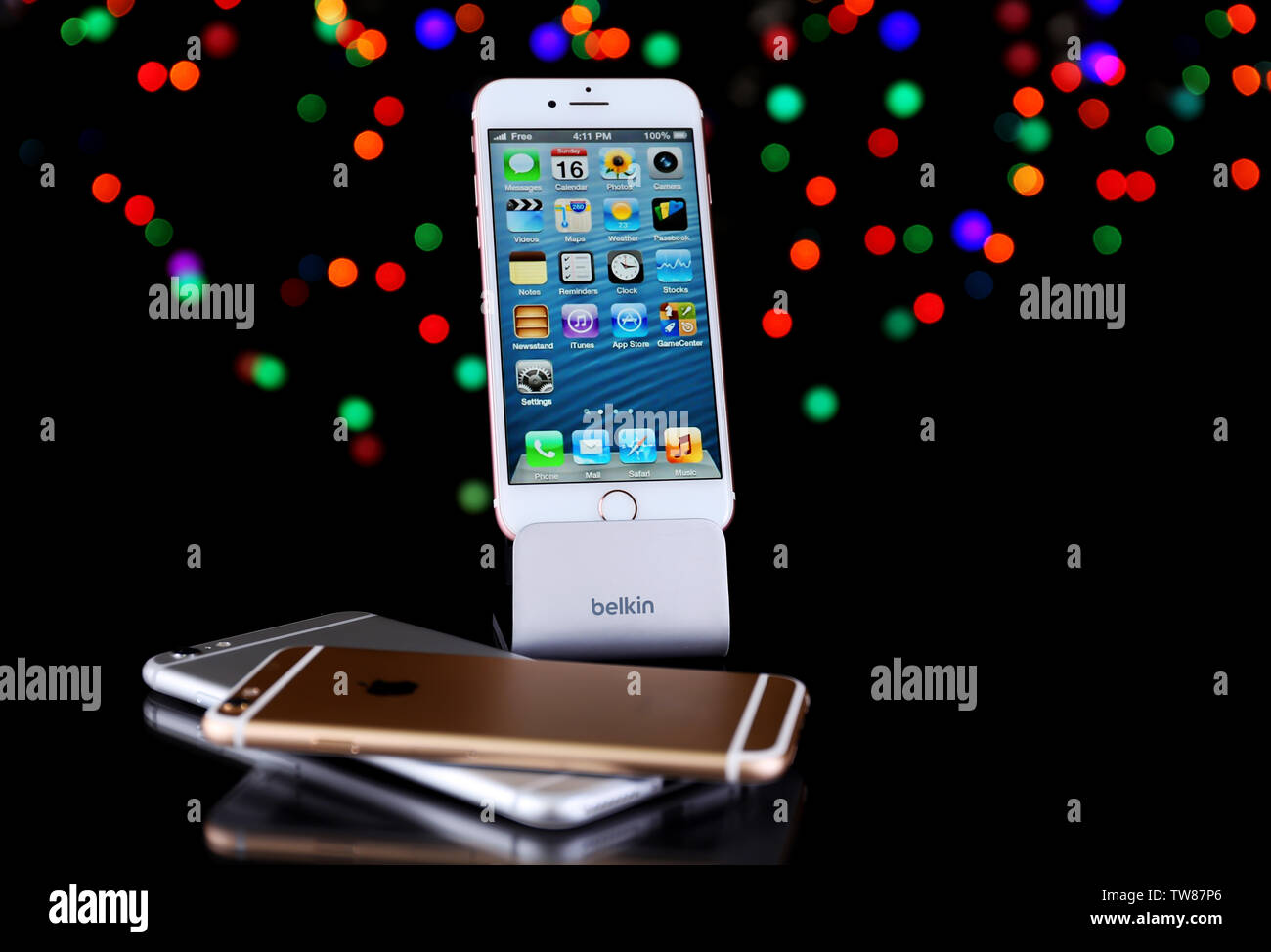 KIEV, UKRAINE - OCTOBER 19, 2017: iPhone 7 Rose gold with home screen on Belkin stand near iPhone 6s Silver and iPhone 6s Gold against blurred lights Stock Photo
