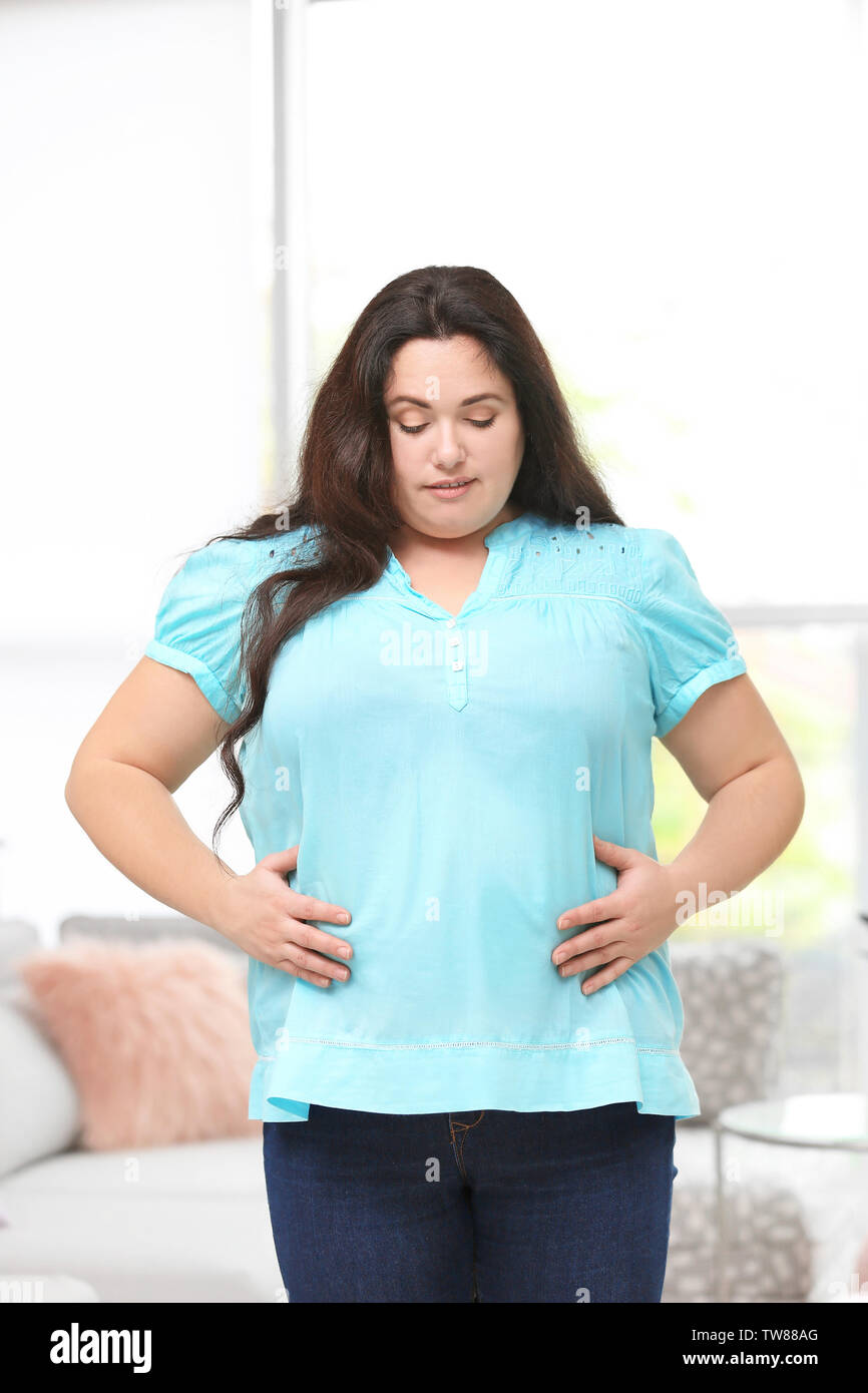 Overweight young woman posing at home Stock Photo