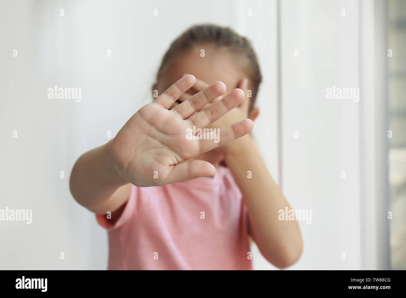 Helpless little girl hiding face. Abuse of children concept Stock Photo -  Alamy