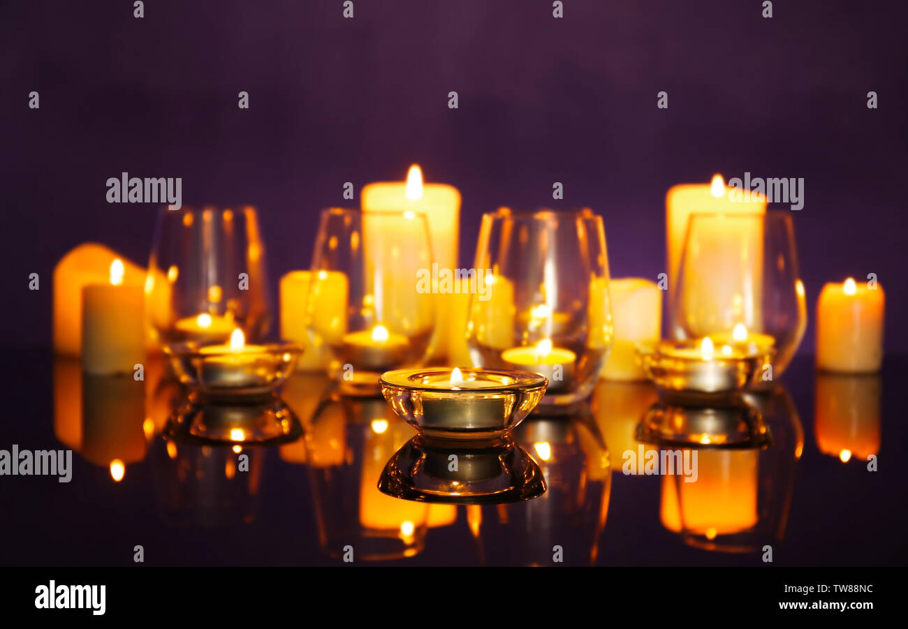 Composition with burning candles on dark background Stock Photo - Alamy