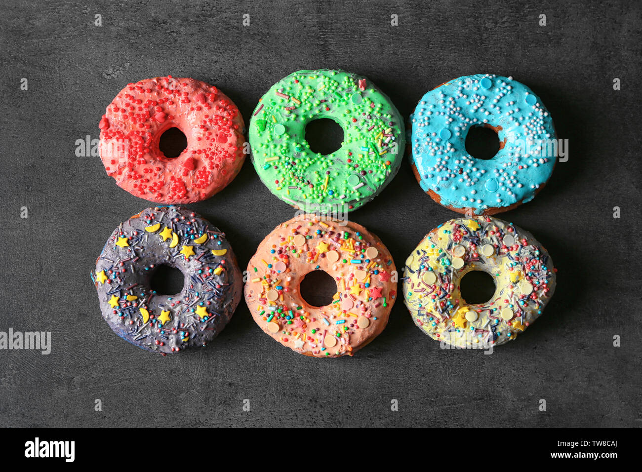 Fresh yummy colorful donuts on grey background Stock Photo - Alamy