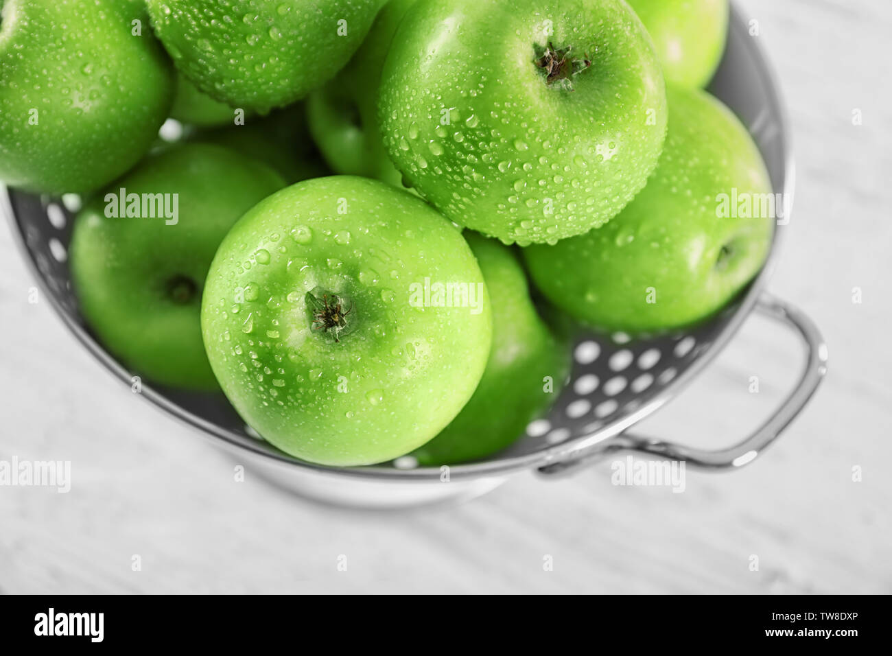 Colander with fresh green apples on table, closeup Stock Photo - Alamy