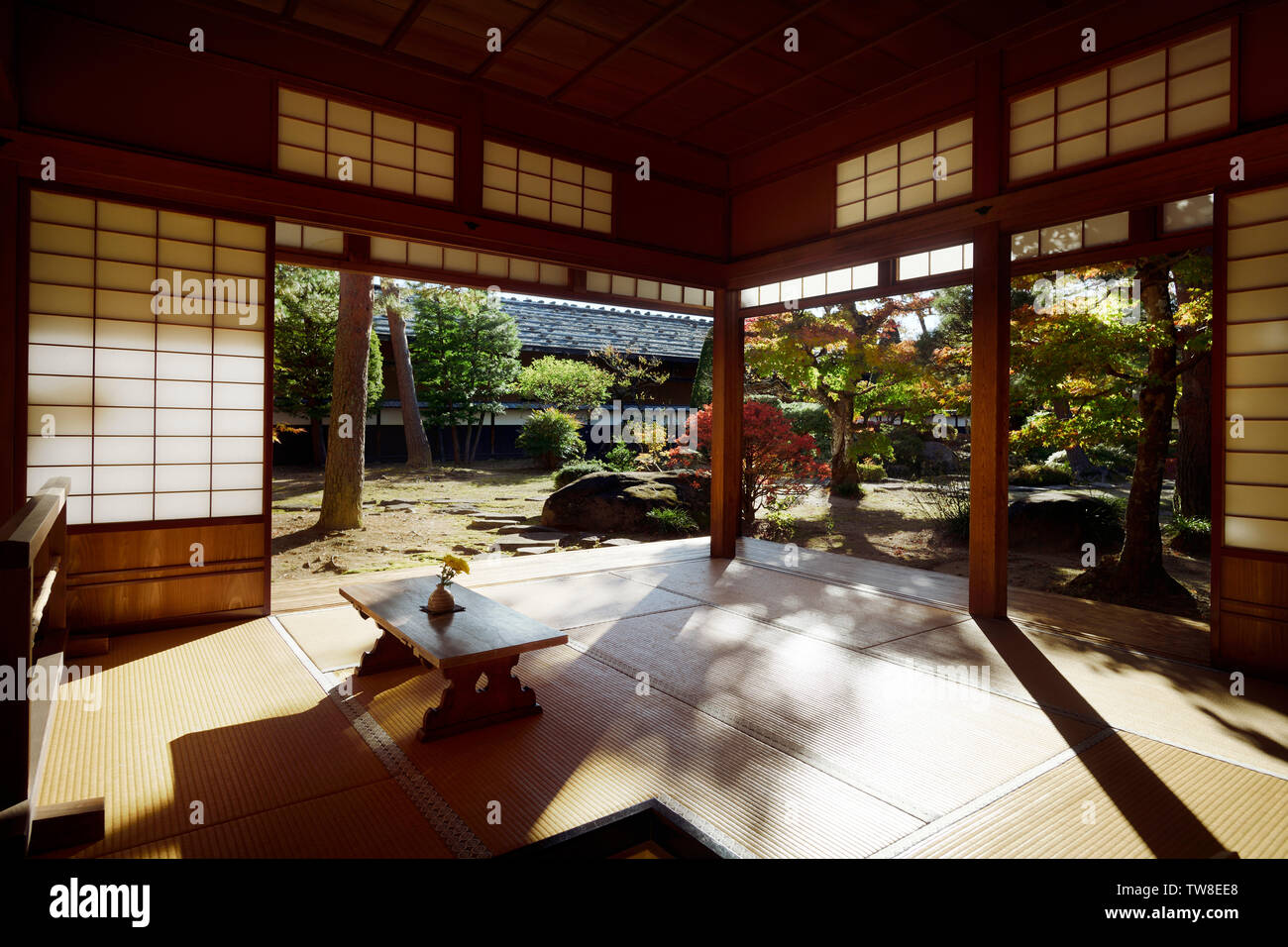 Japanese Edo period building interior. Lit with sunlight traditional room of Takayama Jin'ya, historic house, with an autumn garden view. Stock Photo