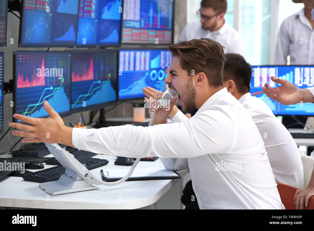 Angry male stock trader working in office Stock Photo