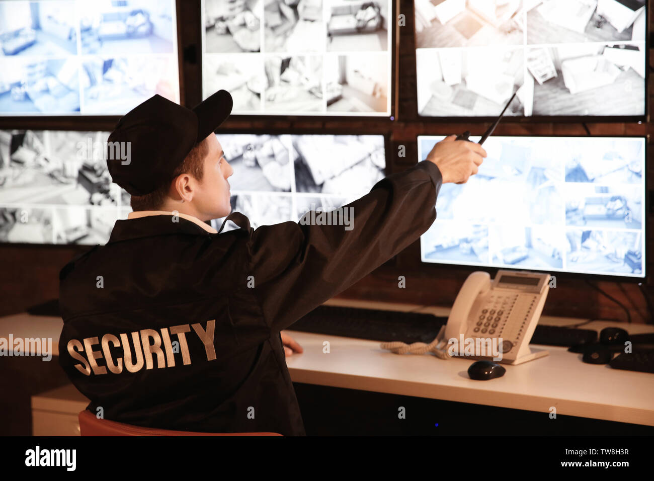 Male security guard working in surveillance room Stock Photo - Alamy