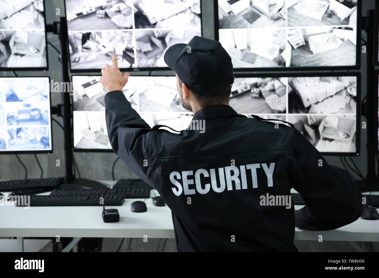 Male security guard working in surveillance room Stock Photo - Alamy