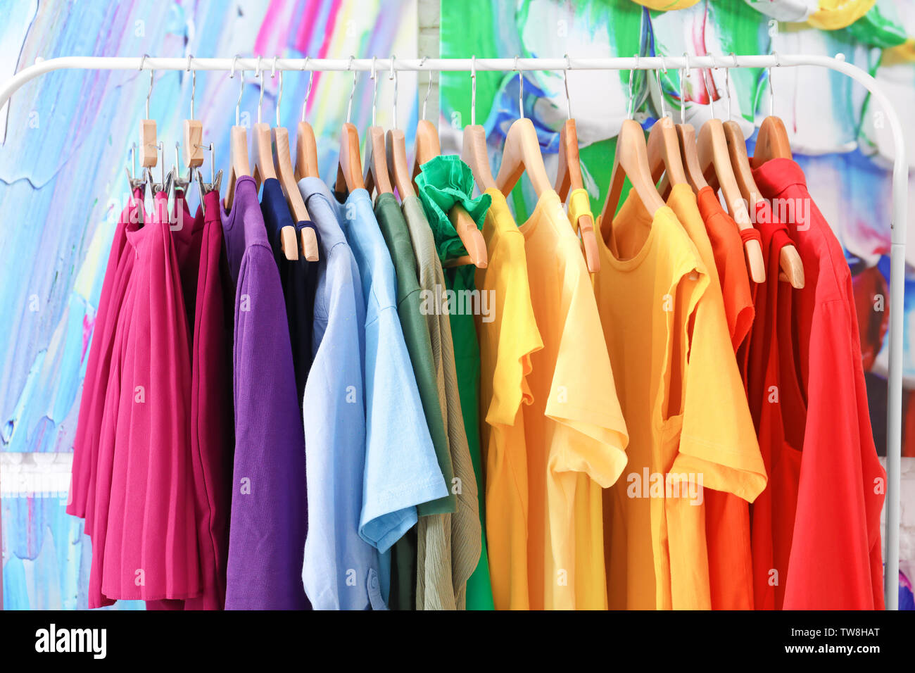 Rainbow clothes hanging on rack Stock Photo - Alamy