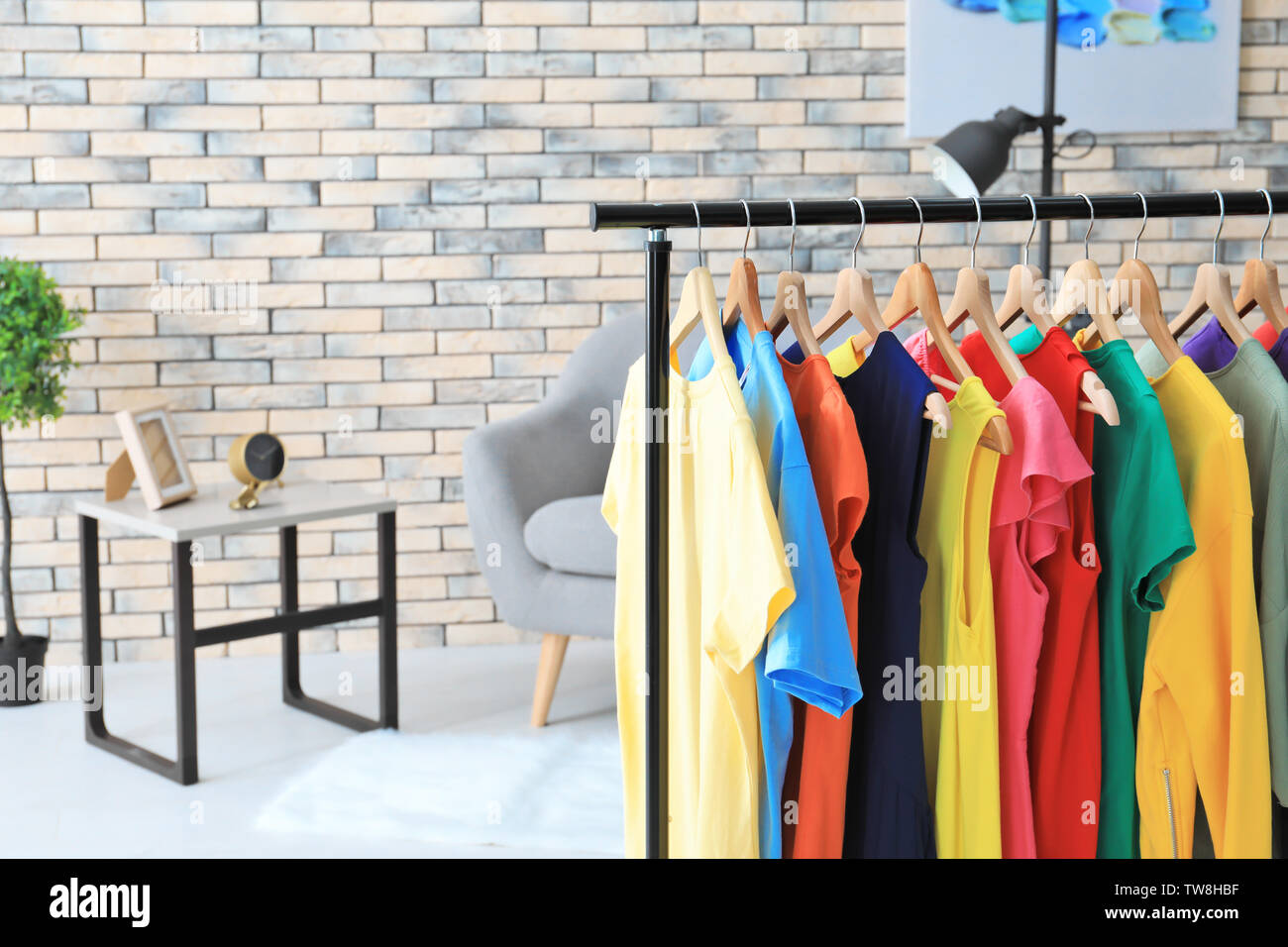Rack with rainbow clothes indoors Stock Photo - Alamy