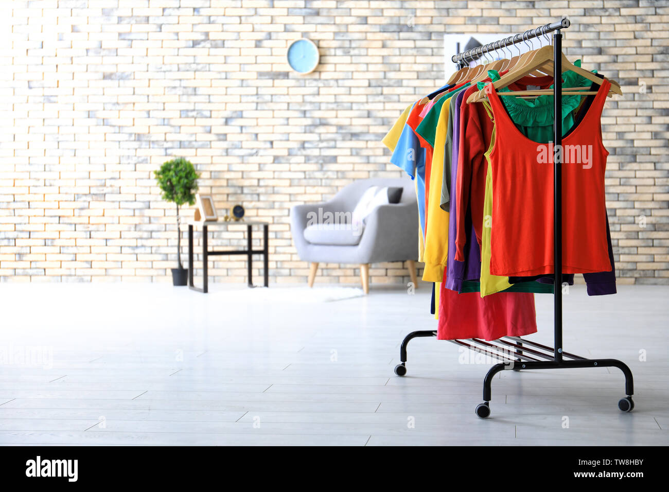 Rack with rainbow clothes indoors Stock Photo - Alamy