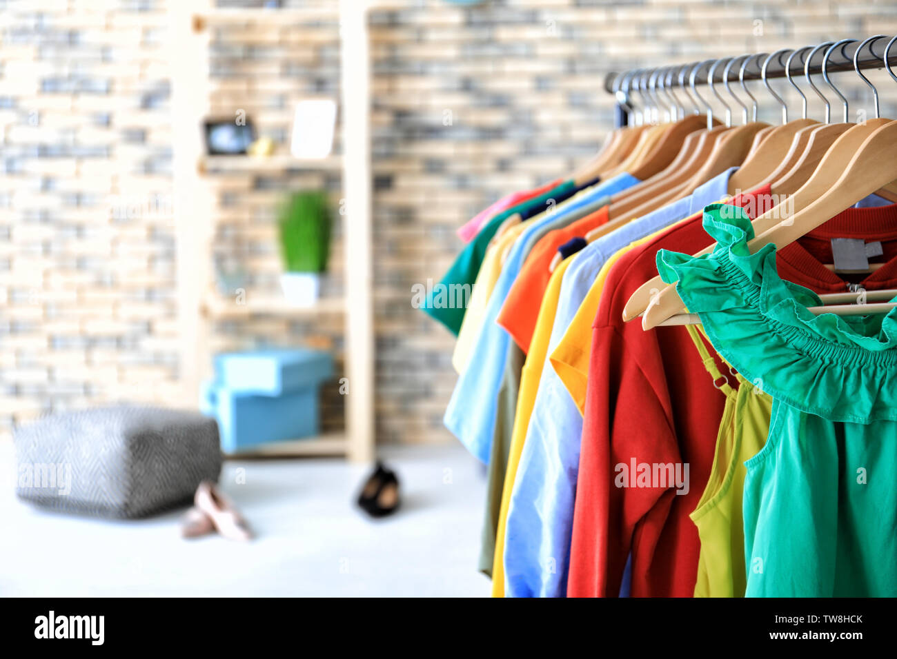 Rack with rainbow clothes indoors Stock Photo - Alamy