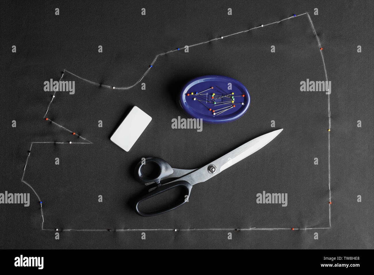 Tailoring scissors, chalk and pins on fabric, top view Stock Photo