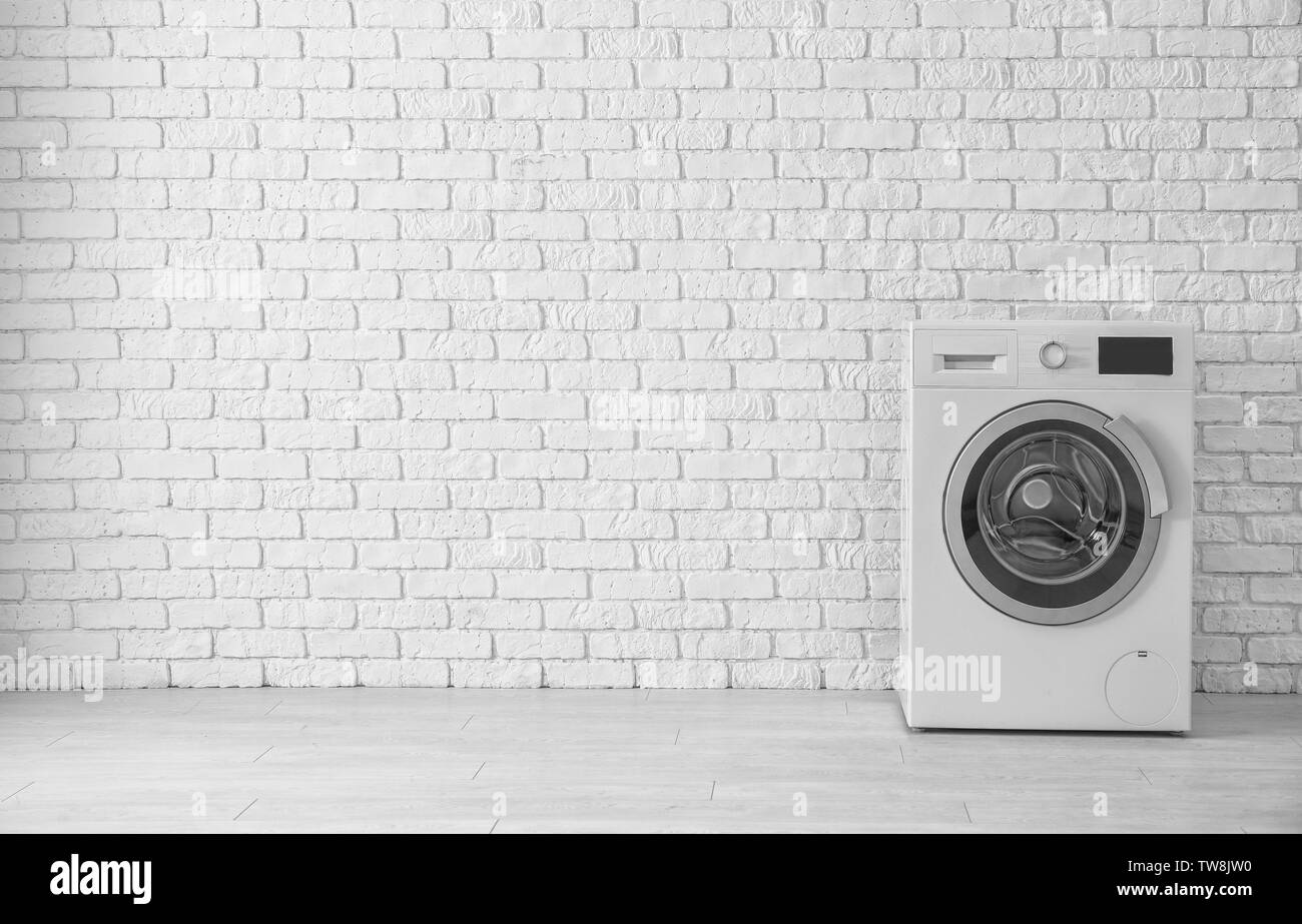 Modern washing machine near brick wall Stock Photo Alamy