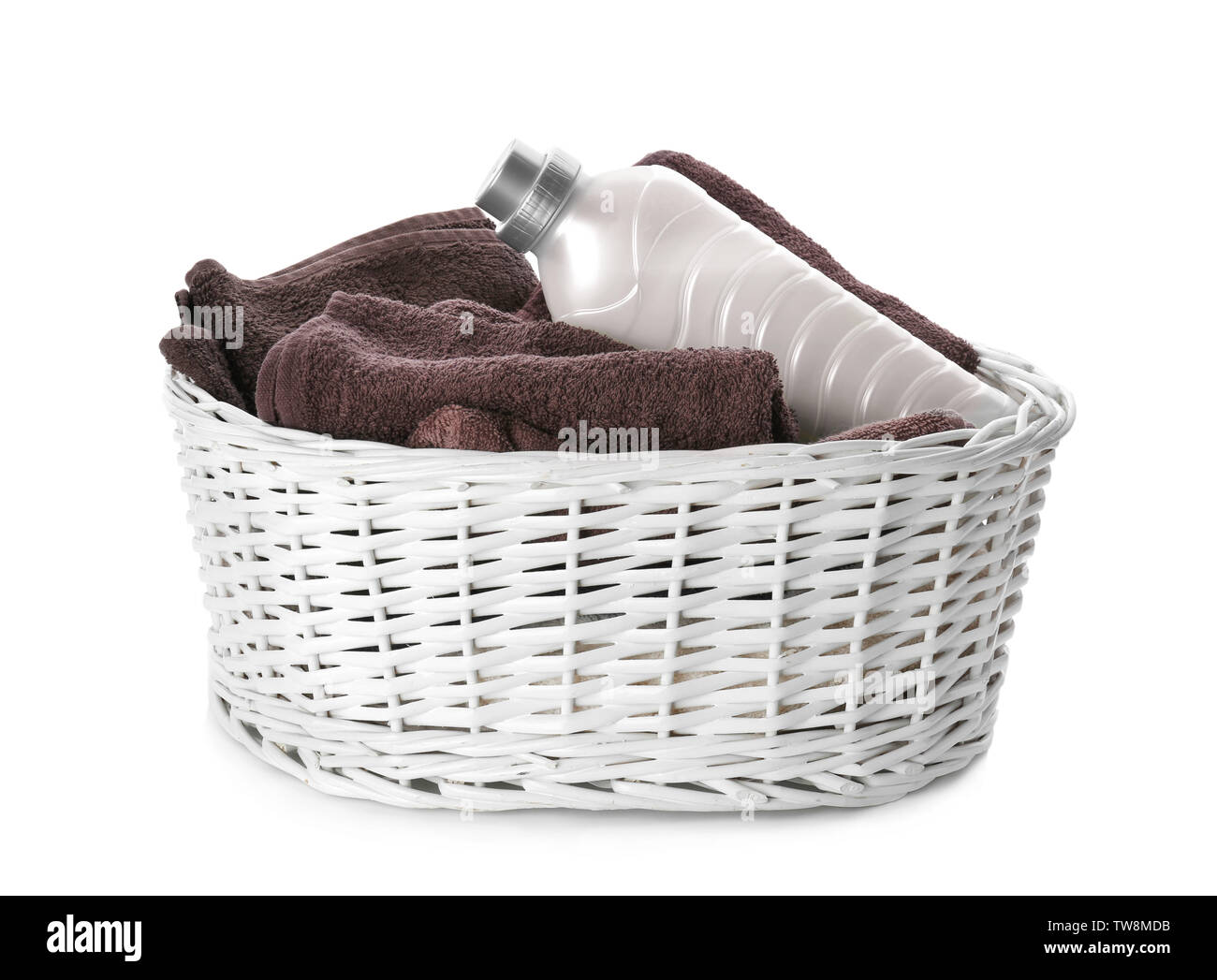 Basket with towels and laundry detergent on white background Stock