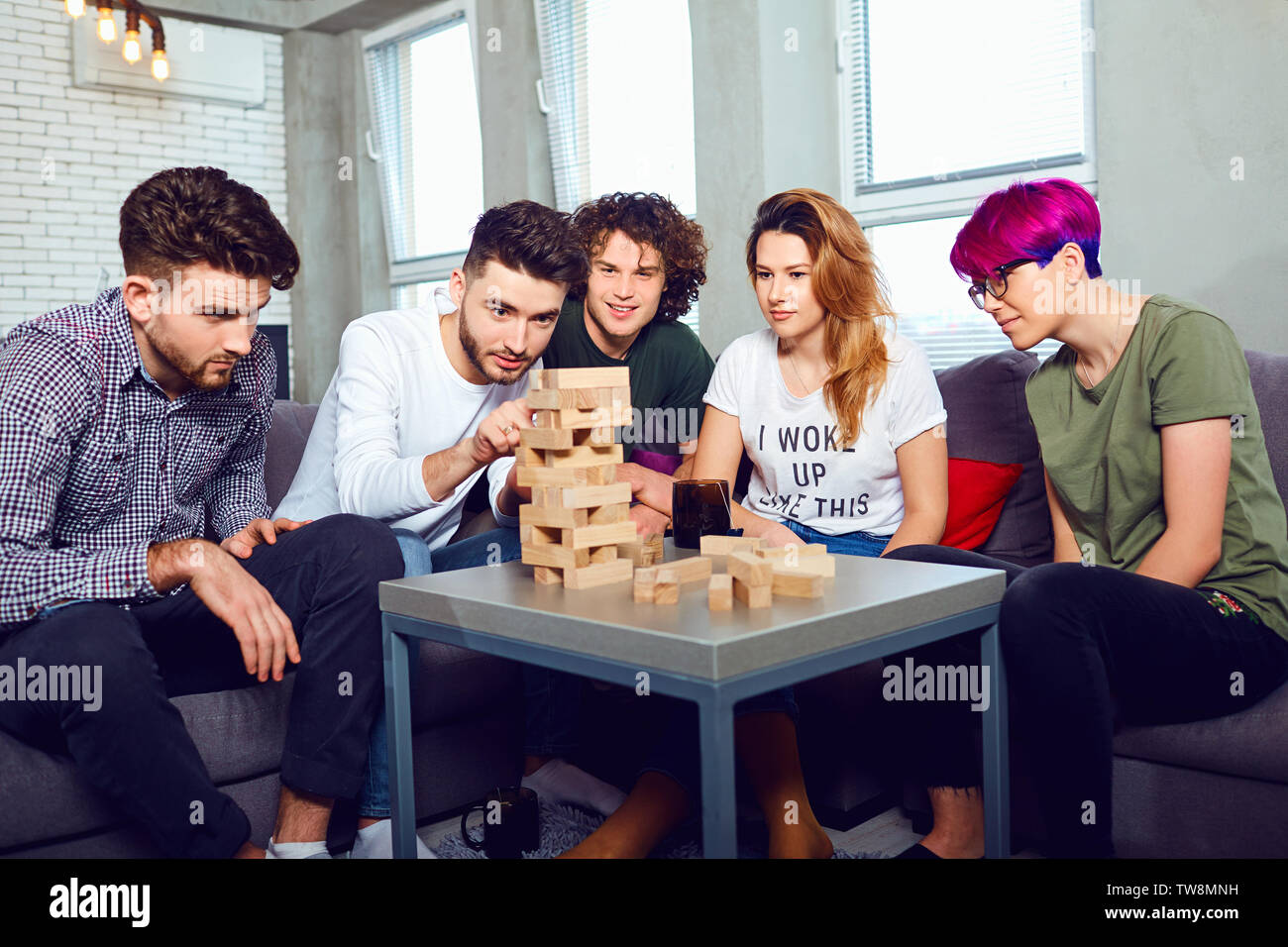 A cheerful group of friends play board games. Stock Photo