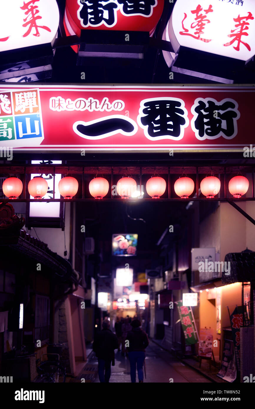 Lit up signs on a street of Takayama city at night. Gifu prefecture, Japan, 2018. Stock Photo