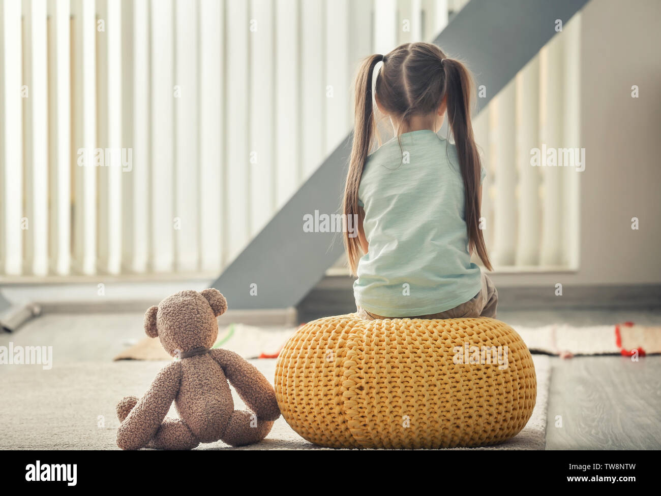 Lonely little girl with teddy bear at home. Autism concept Stock Photo ...