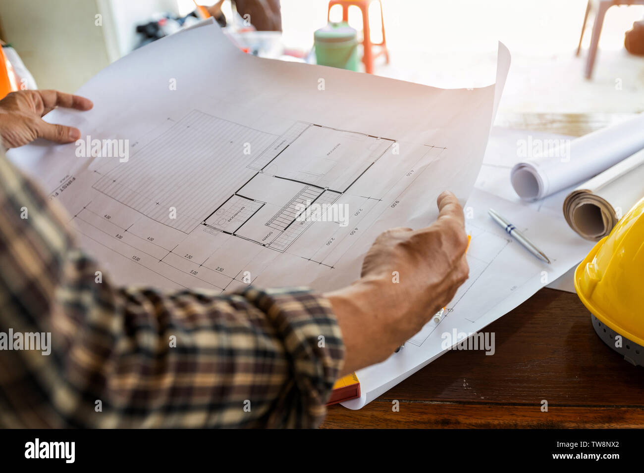 Engineer or foreman with blueprint in building construction site Stock Photo