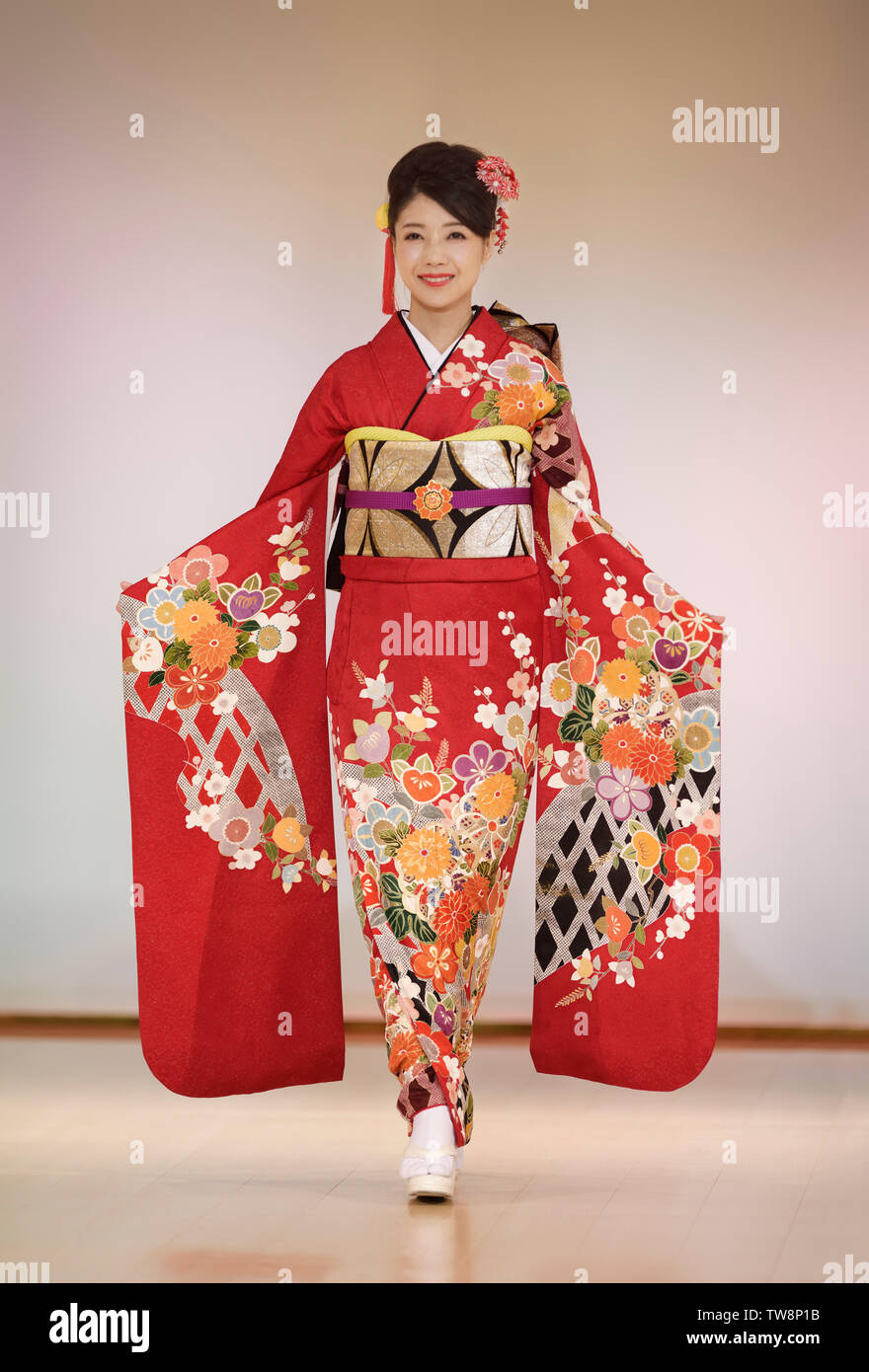 Japanese woman in a beautiful bright red kimono with long sleeves on a  fashion show podium in Kyoto, Japan Stock Photo - Alamy