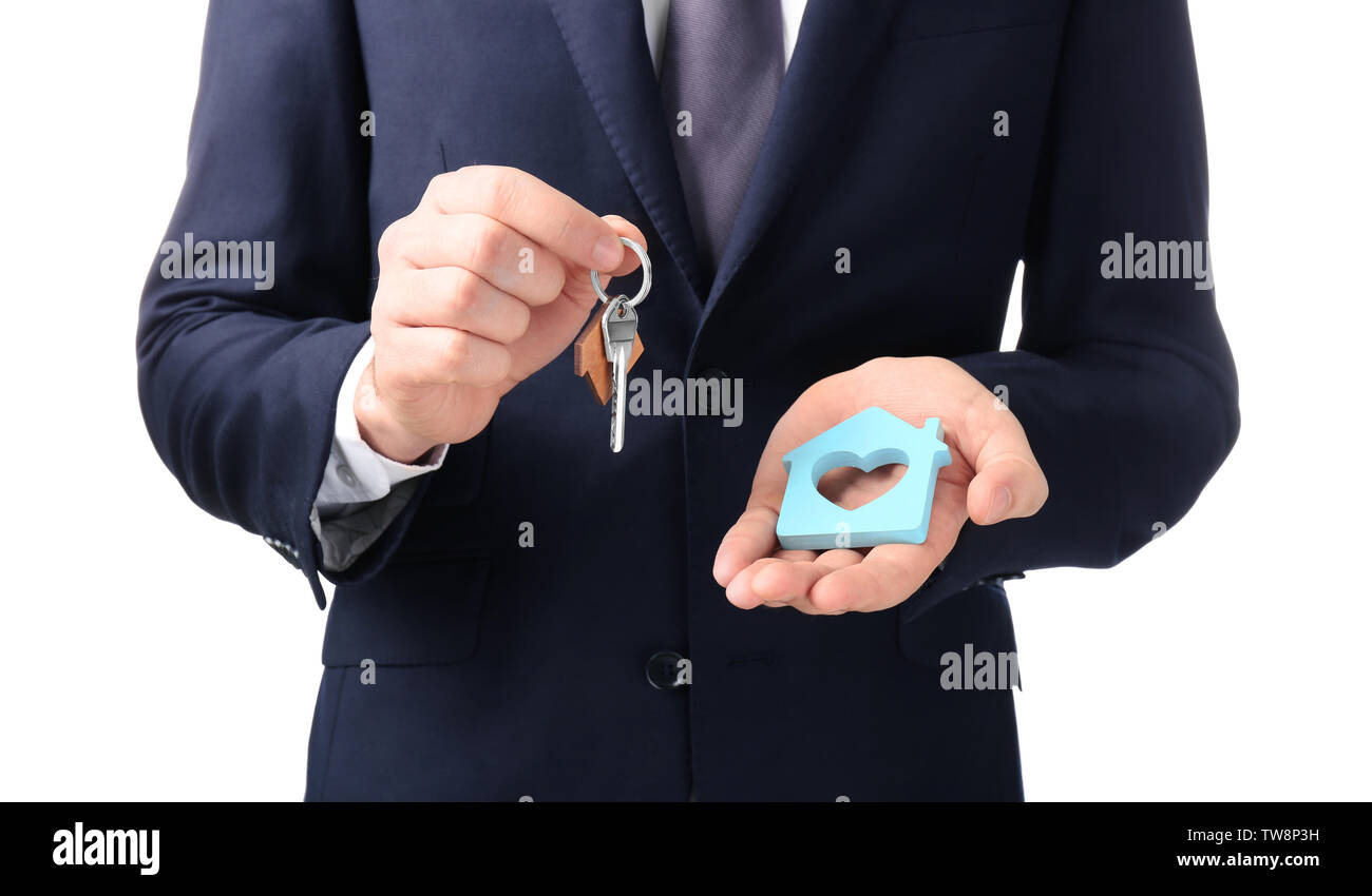 Real estate agent holding house model and key on white background Stock ...