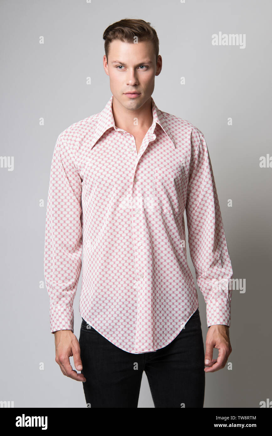 A White brown hair Caucasian male model posing in a red vintage 70s dress shirt. Stock Photo