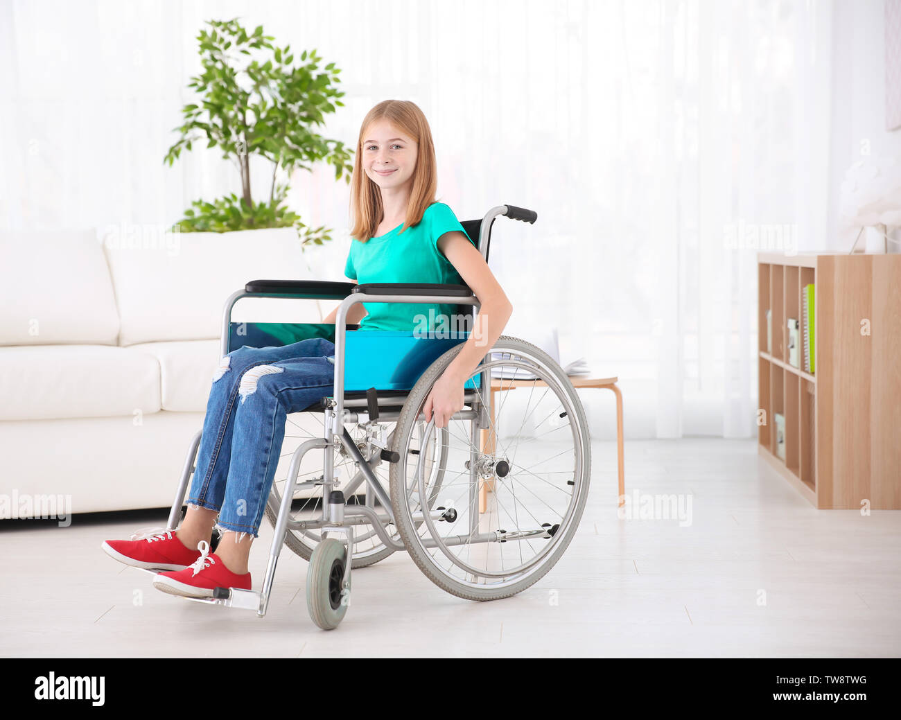 Teenage girl in wheelchair indoors Stock Photo - Alamy
