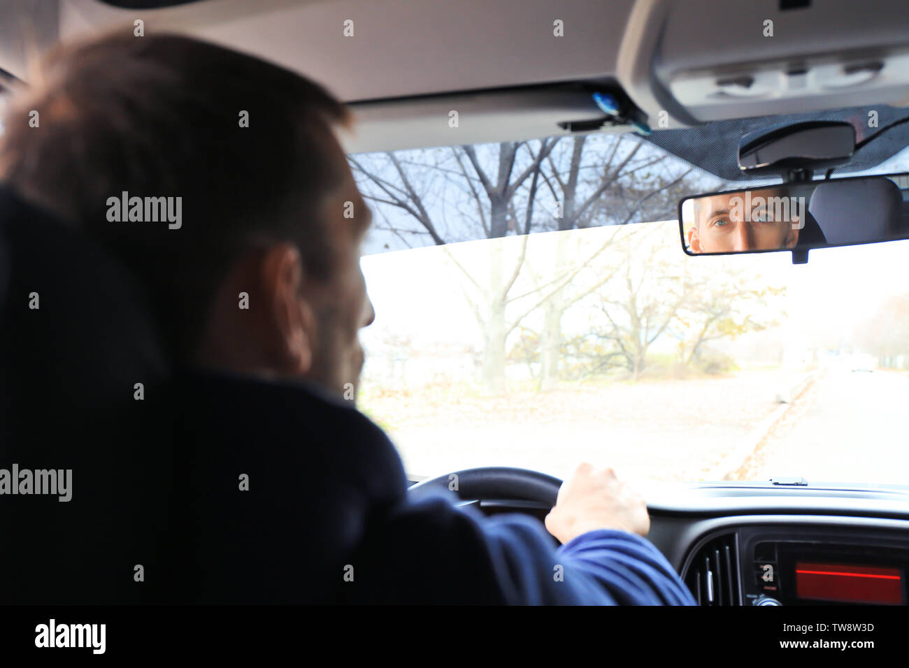 Man looking rear view mirror in car hi-res stock photography and images ...