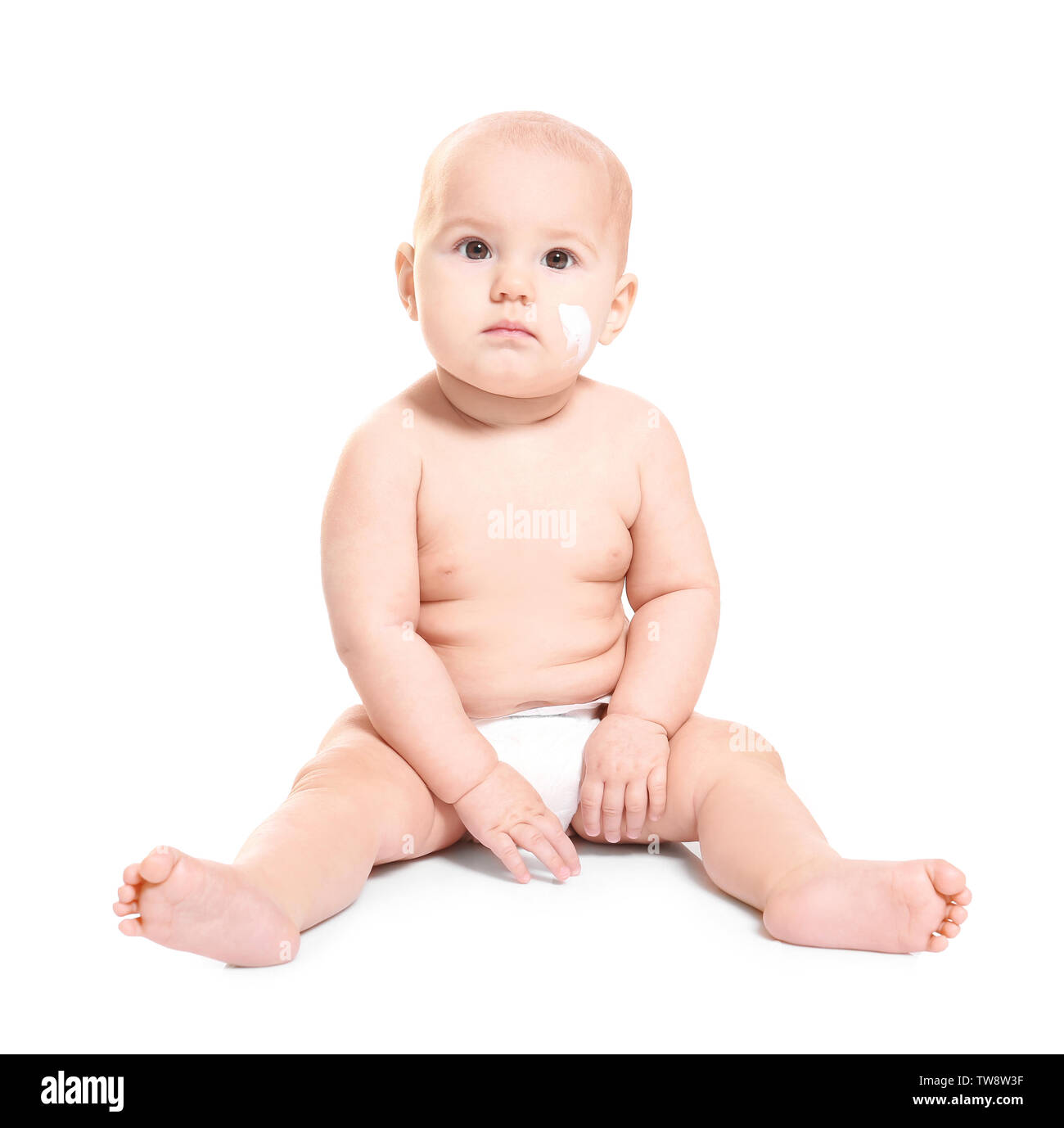 Cute baby with body cream on cheek against white background Stock Photo