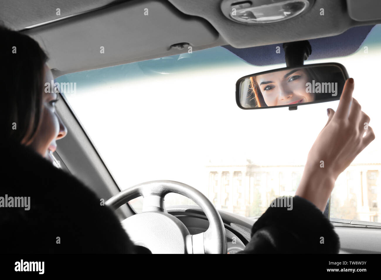 Woman adjusting rear view mirror in car Stock Photo Alamy