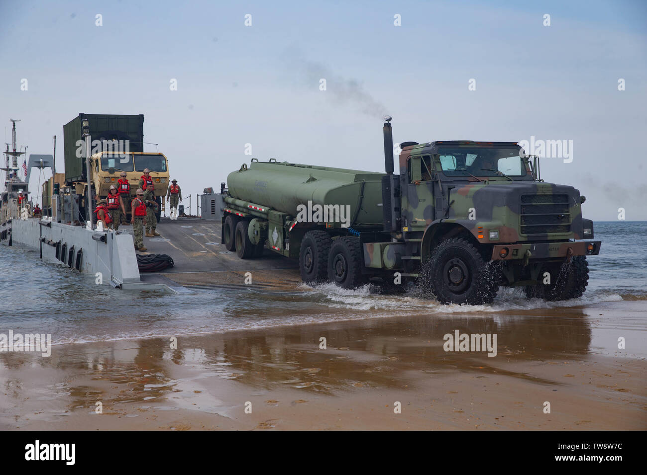 A U.S Marine Corps M970 semitrailer refueling truck with 2nd Transportation Support Battalion, Combat Logistics Regiment 2, 2nd Marine Logistics Group drives off a Navy improved navy lighterage system with Amphibious Construction Battalion 2, Naval Beach Group 2during exercise Resolute Sun at Fort Story, Virginia, June 17, 2019. U.S. Marines participated in the exercise to increase combat operational readiness in amphibious and prepositioning operations while conducting joint training with U.S. Army during a joint logistics over the shore scenario. (U.S. Marine Corps photo by Lance Cpl. Scott Stock Photo