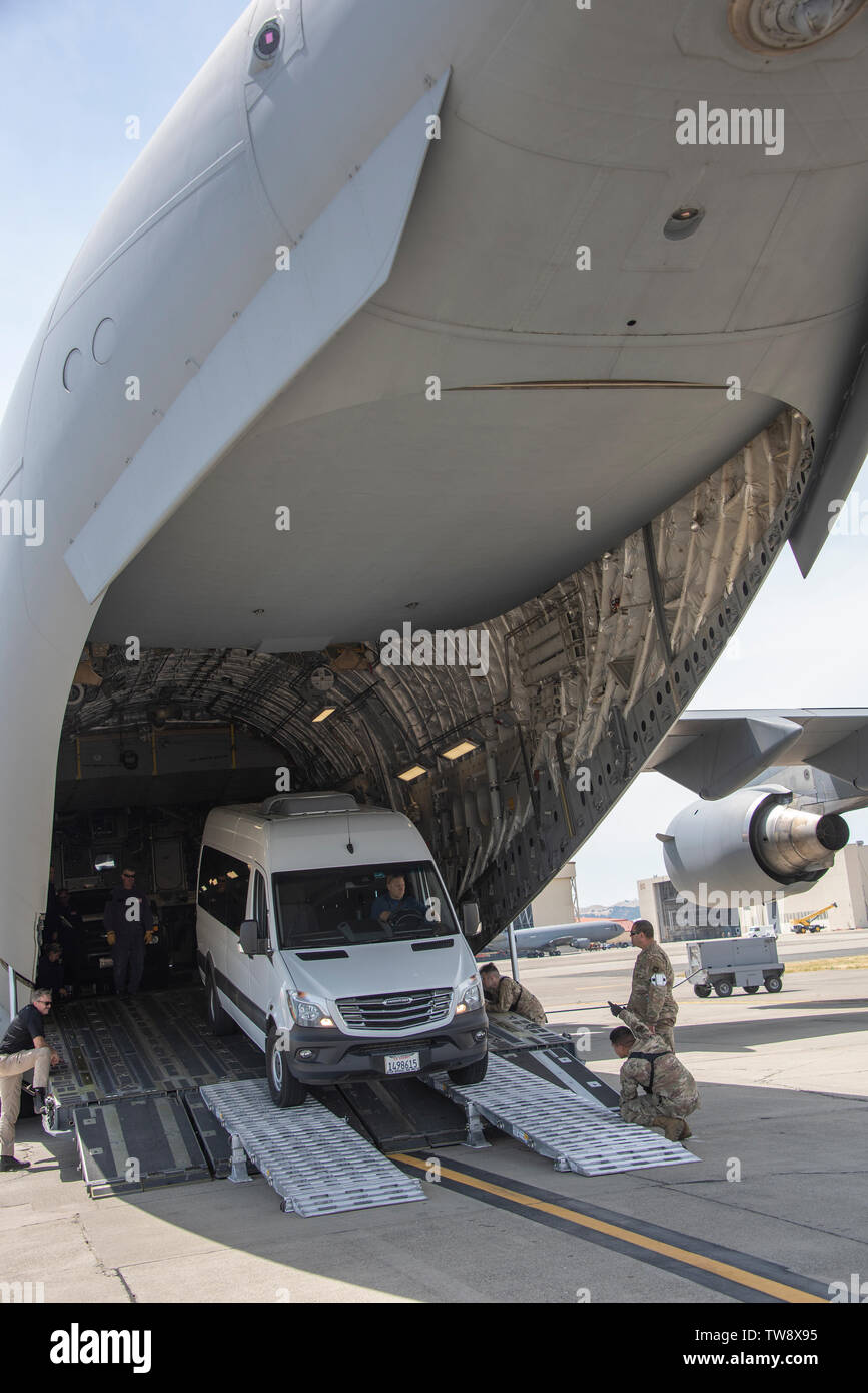 60th Aerial Port Squadron personnel guide a California Urban Search and Rescue Task Force 7 emergency response vehicle into the cargo bay of a C-17 Globemaster III during a joint inspection and logistics drill June 13, 2019 at Travis Air Force Base, California. The annual training helps members of CA TF-7 learn about the process, governing and directives and ensures cargo is safe before loading onto an aircraft.  (U.S. Air Force photo by Heide Couch) Stock Photo