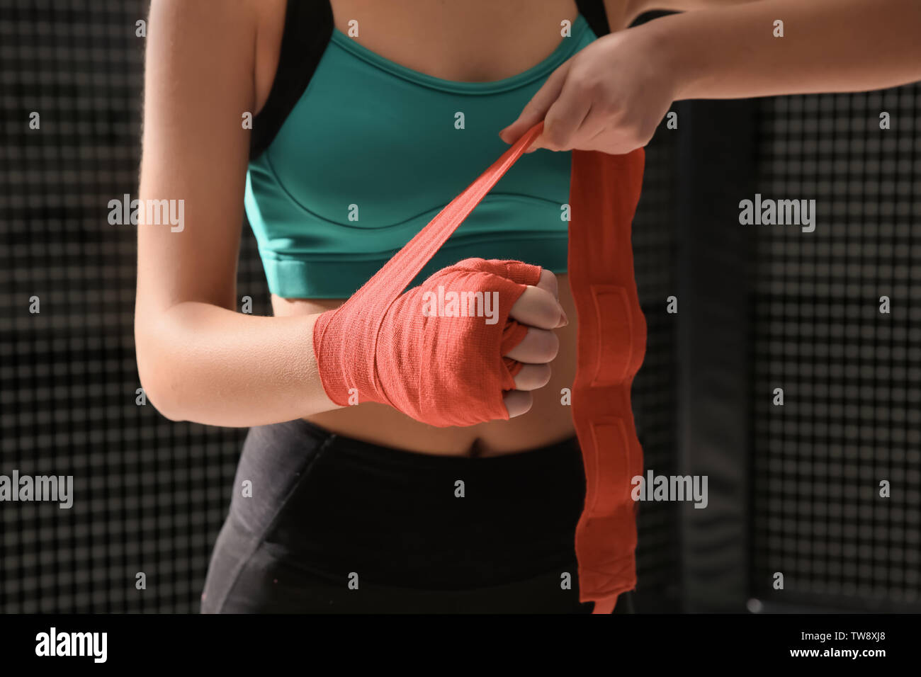 Young female boxer applying wrist wraps in gym Stock Photo Alamy