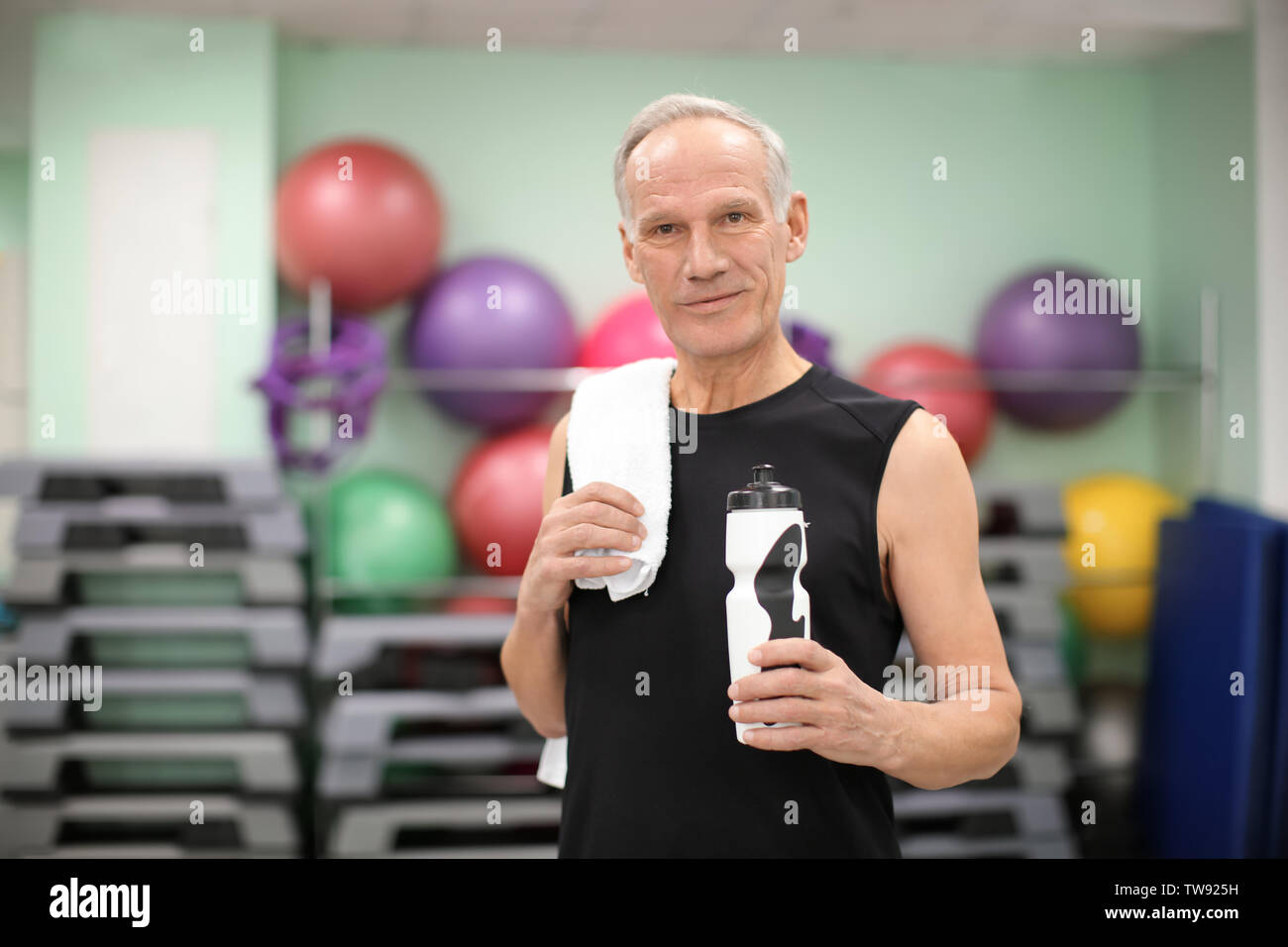 Elderly man with bottle of water in gym Stock Photo - Alamy