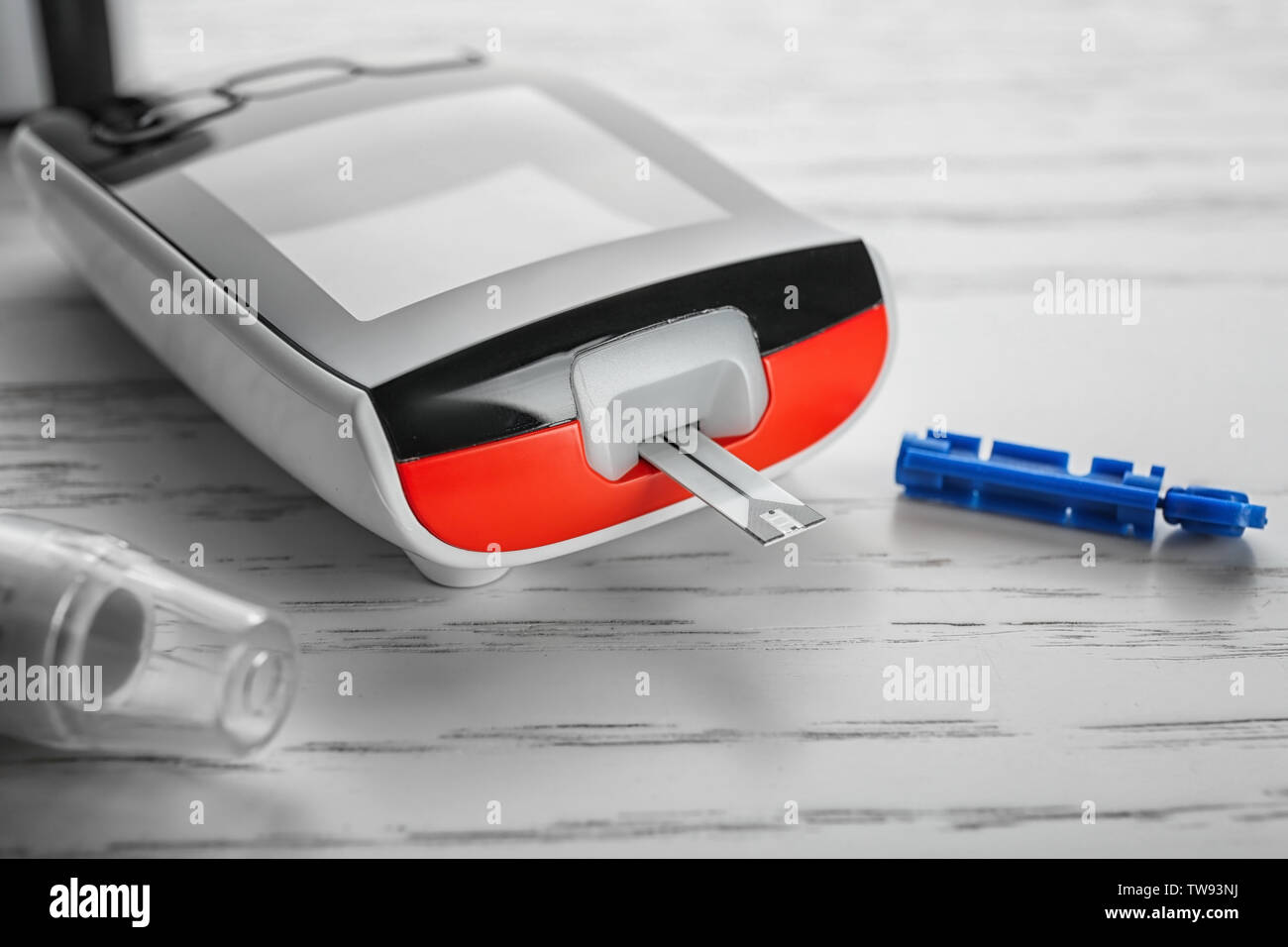Digital glucometer on light background, closeup. Diabetes management