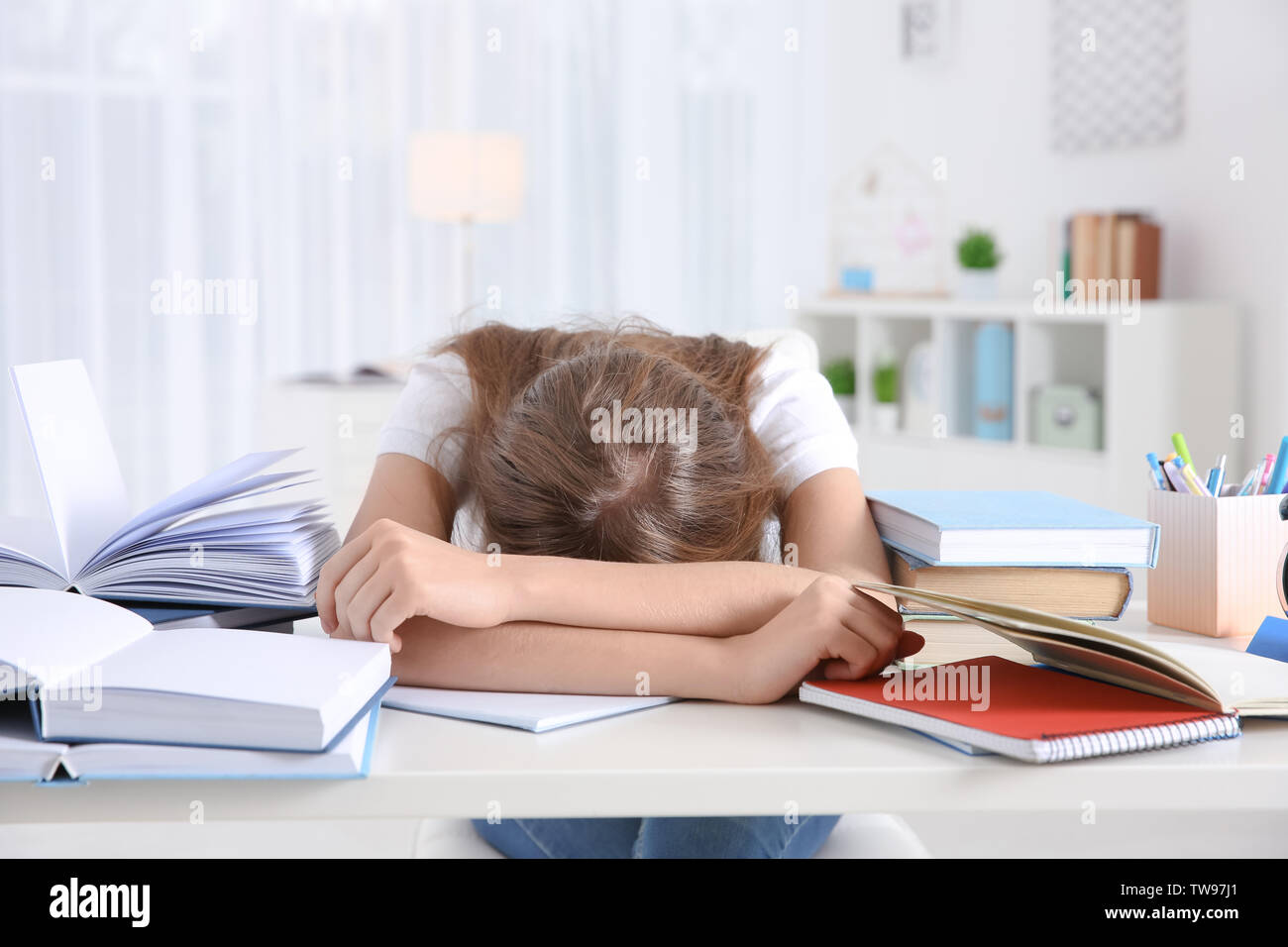 Tired student sleeping at her desk. Preparing for exam Stock Photo