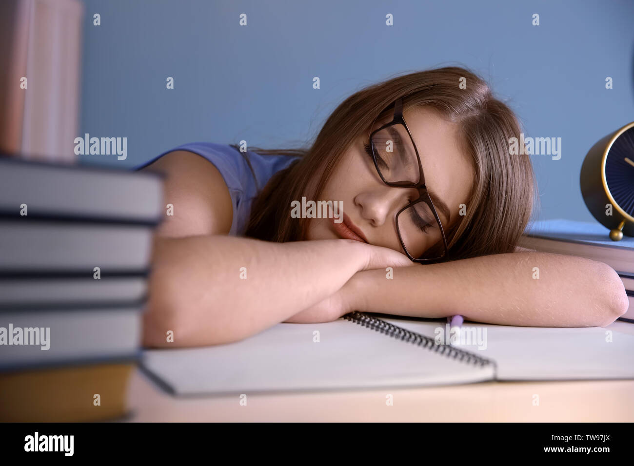 Tired Student Sleeping At Her Desk Preparing For Exam Stock Photo