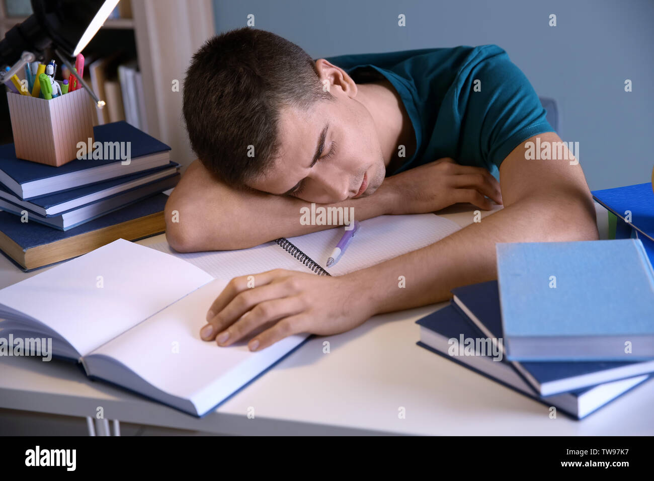 Tired Student Sleeping At His Desk Indoors Preparing For Exam