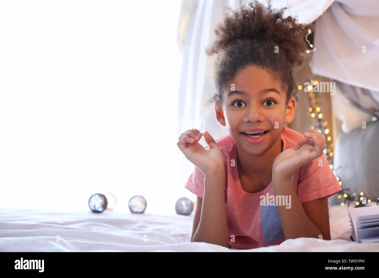 Cute African American girl lying on bed Stock Photo - Alamy