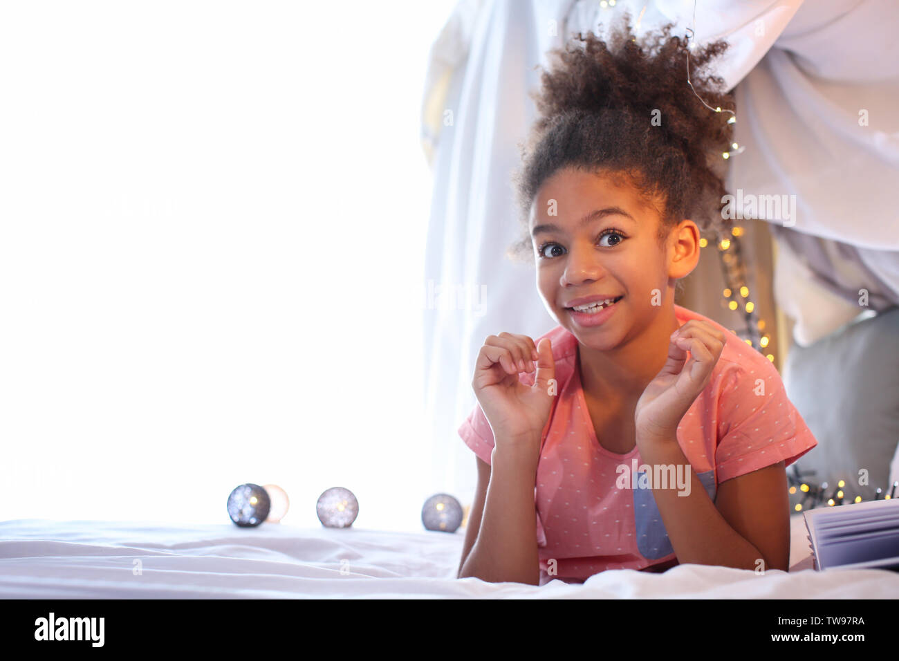 Cute African American girl lying on bed Stock Photo - Alamy
