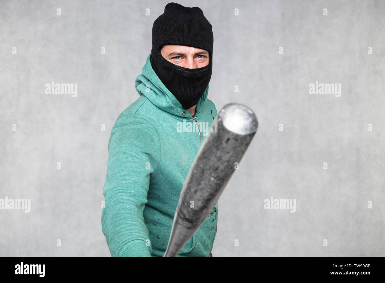 a masked hooligan holds a baseball bat in his hand Stock Photo - Alamy