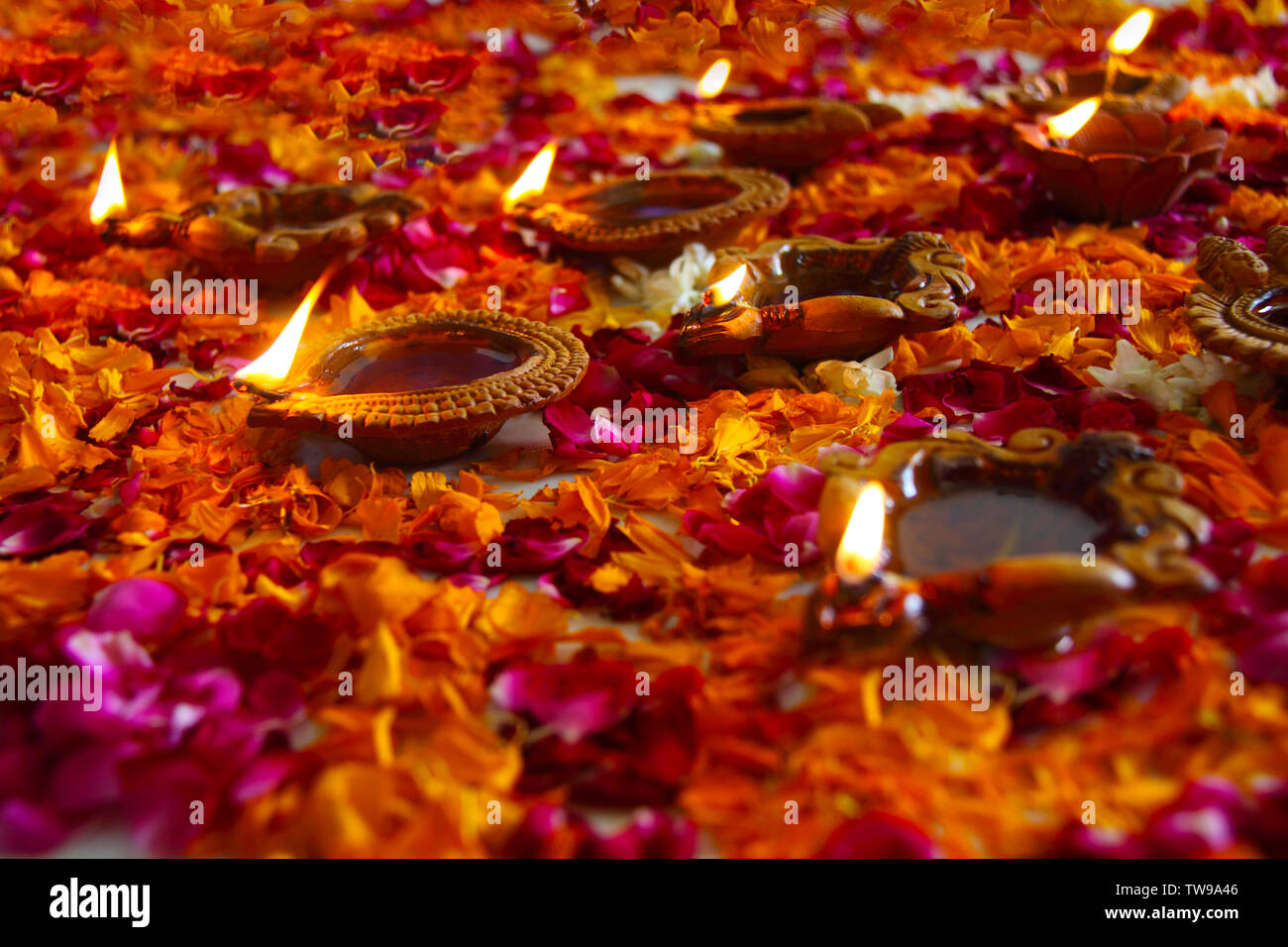 Close up of a colorful rangoli with oil lamps Stock Photo