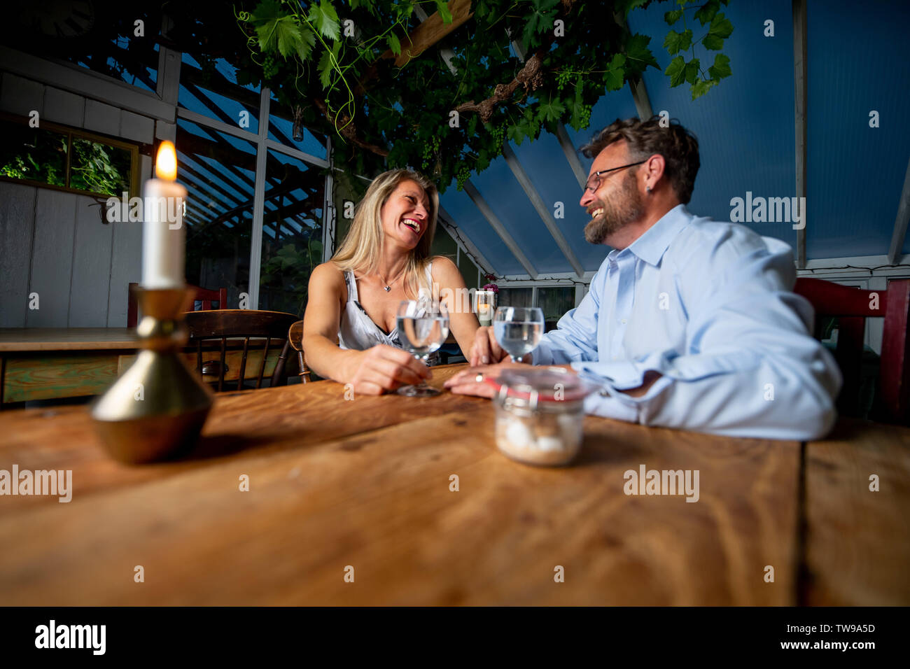 Couple sit together relaxing at a table Stock Photo