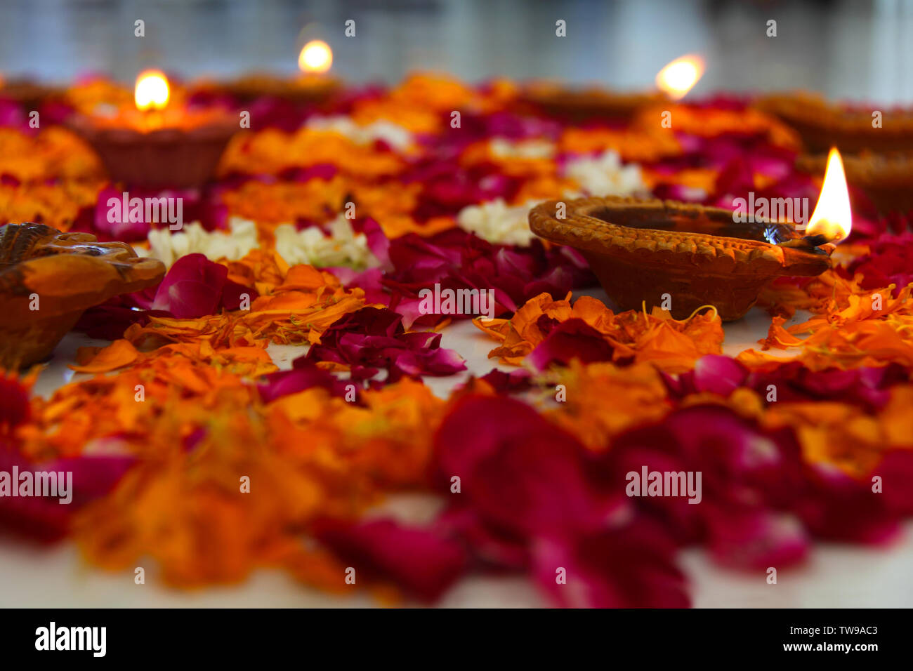 Close up of a colorful rangoli with oil lamps Stock Photo