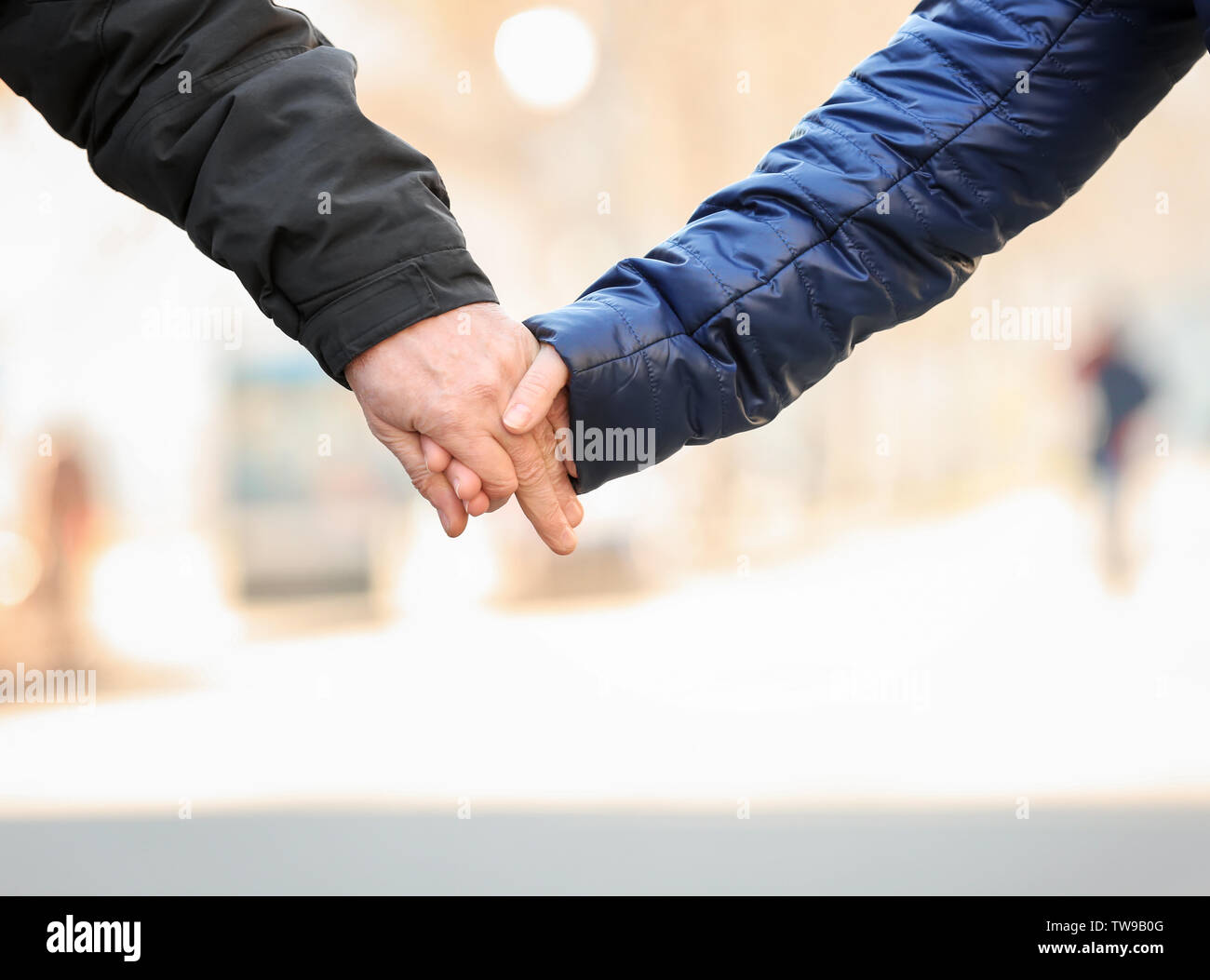 Happy mature couple holding hands outdoors, closeup Stock Photo