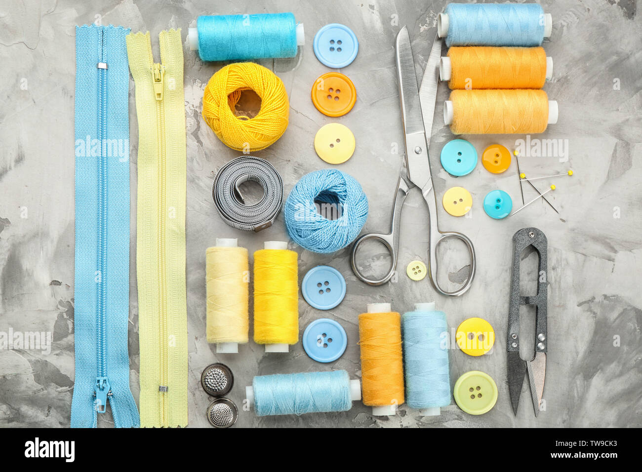Colorful threads and sewing accessories on grey background Stock Photo ...